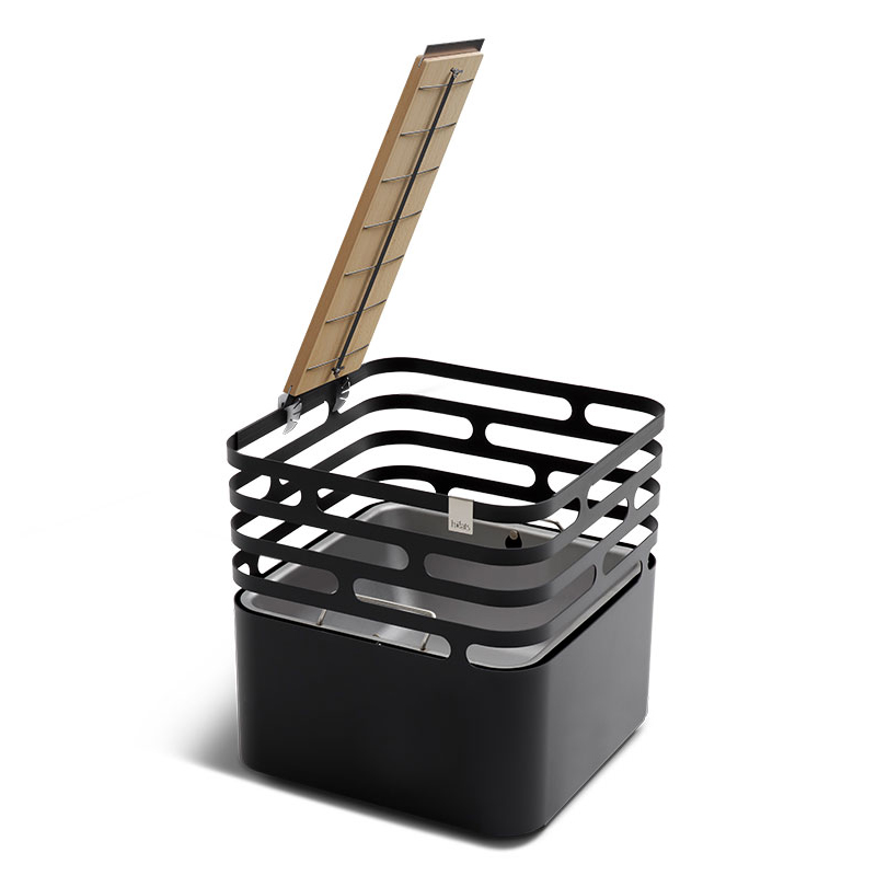 A black firebasket, the Cube, and a Wooden Board with a grid to hold a salmon for grilling and a discount icon. The Flame-grilled salmon board is shown