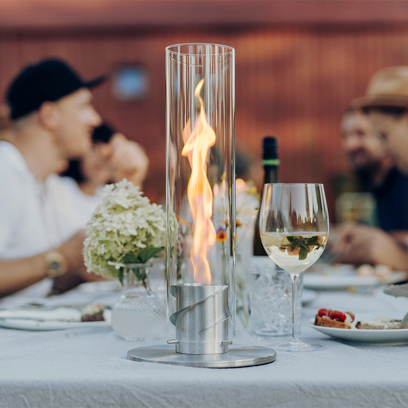 A table with a tablefire and a wine glass, enriched by the presence of the Spin 900, which merges design with utility.