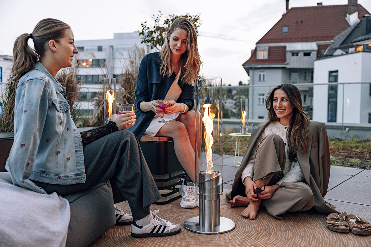 SPIN 1500 Stand Elevation silver Two women sitting on a bench, enriched by the presence of the 00629 Spin 1500 elevation silver, which merges design with utility.