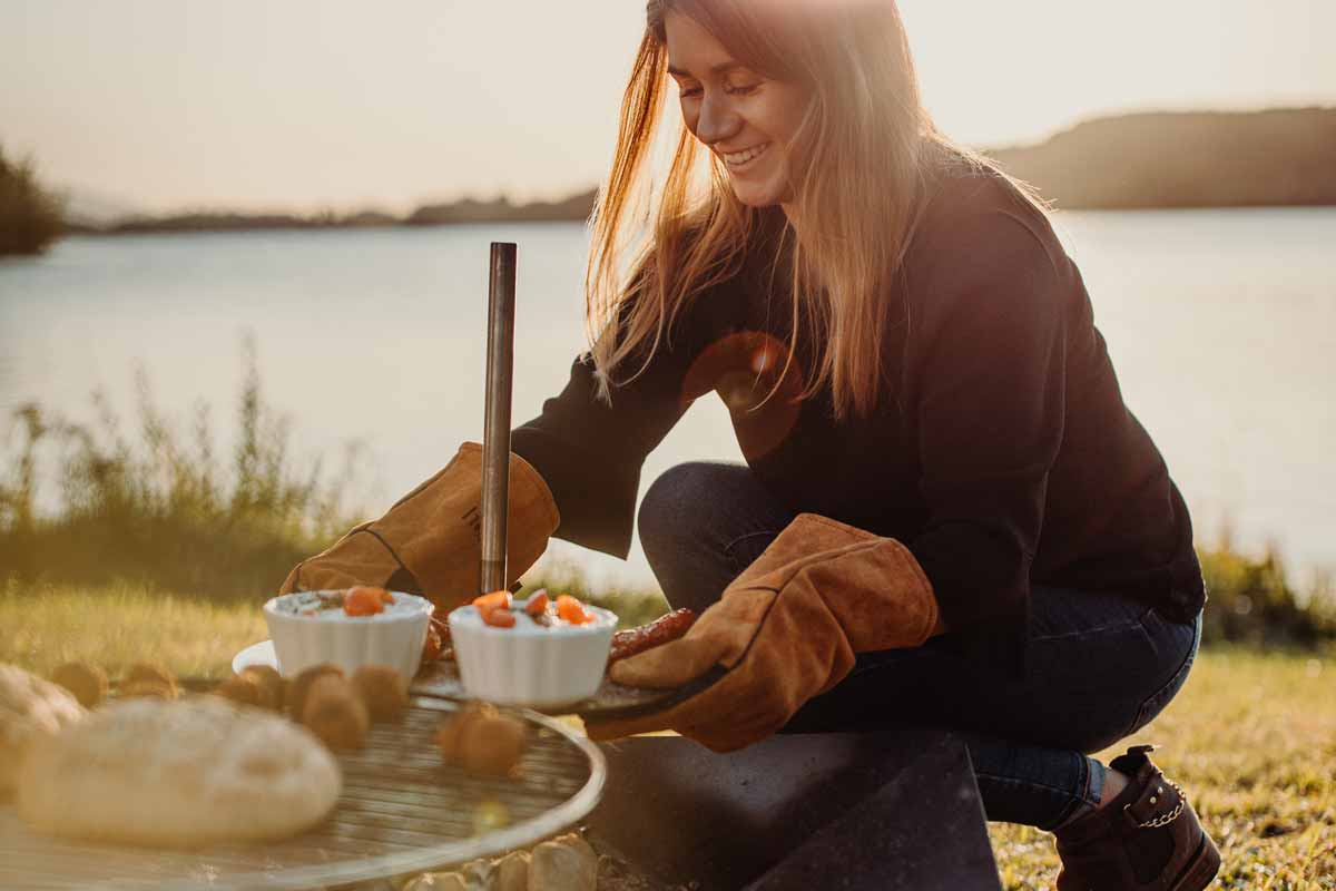TRIPLE Table Depicted here is a woman sitting on the grass by the water, with the TRIPLE Table.