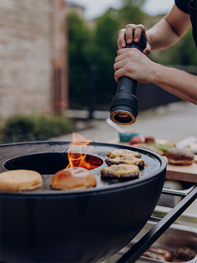 This image shows a man cooking food on a grill