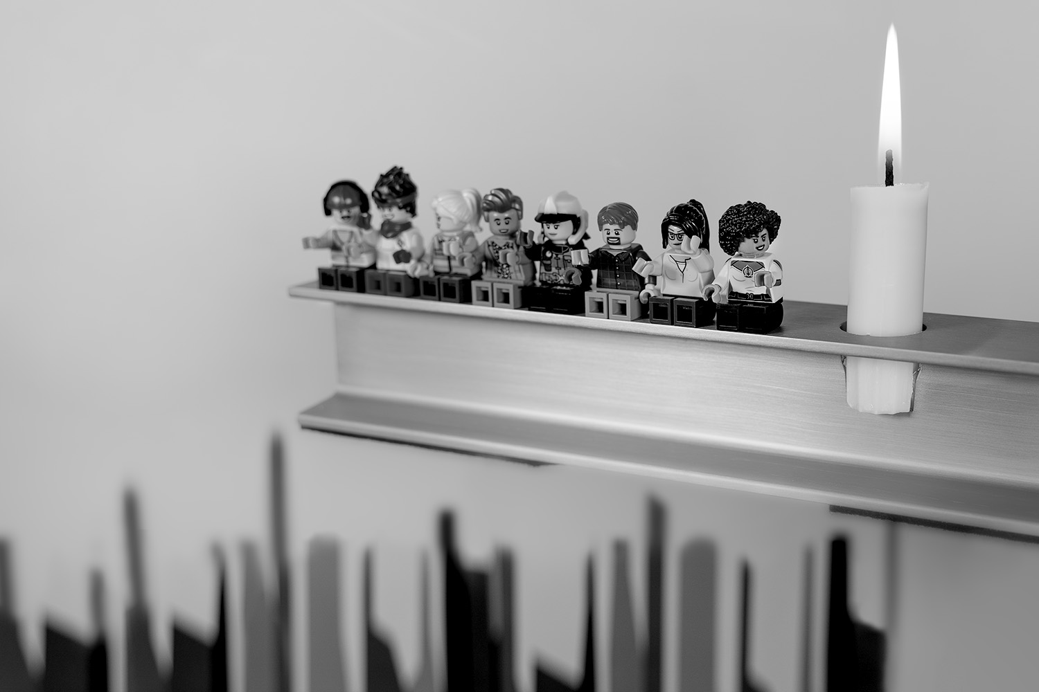 a candle and legos on a shelf.