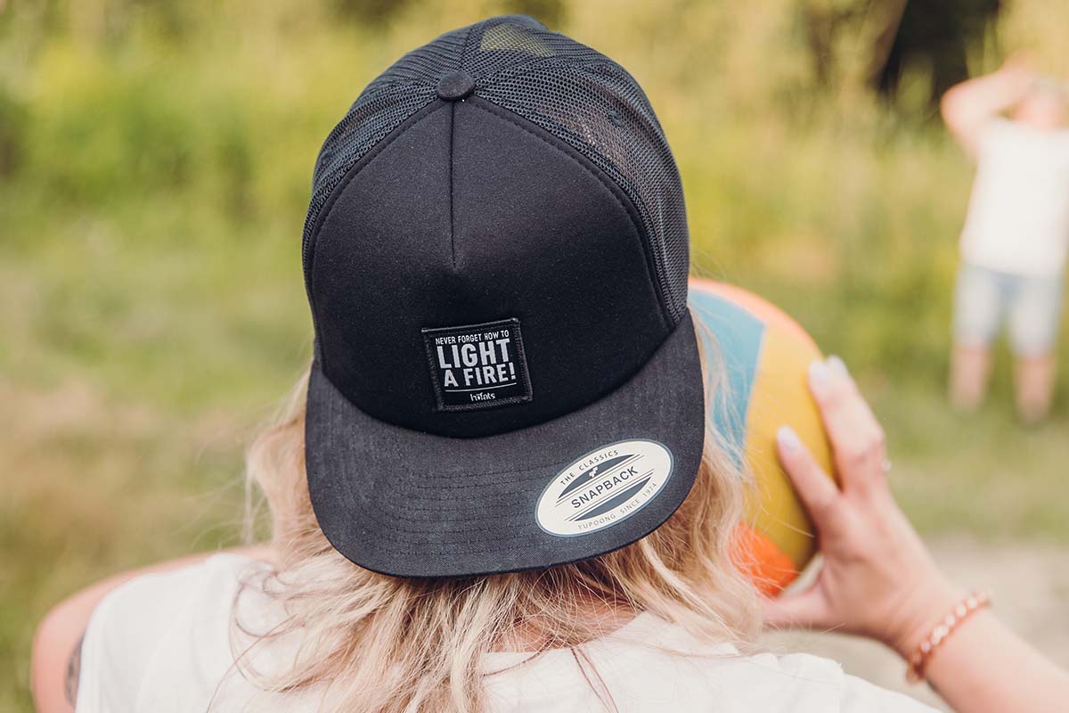 CAP black a woman wearing a black hat with the words light up.