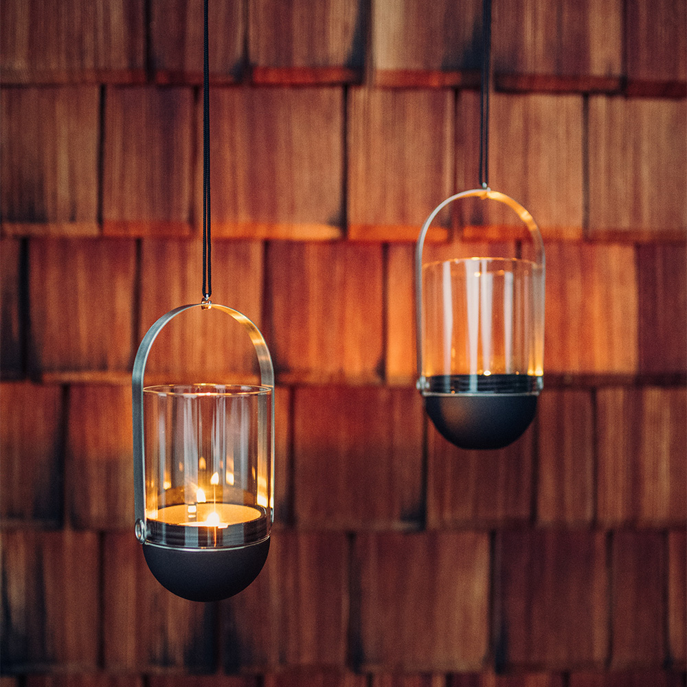 two hanging lights with candles inside of them, showing the gravity candles