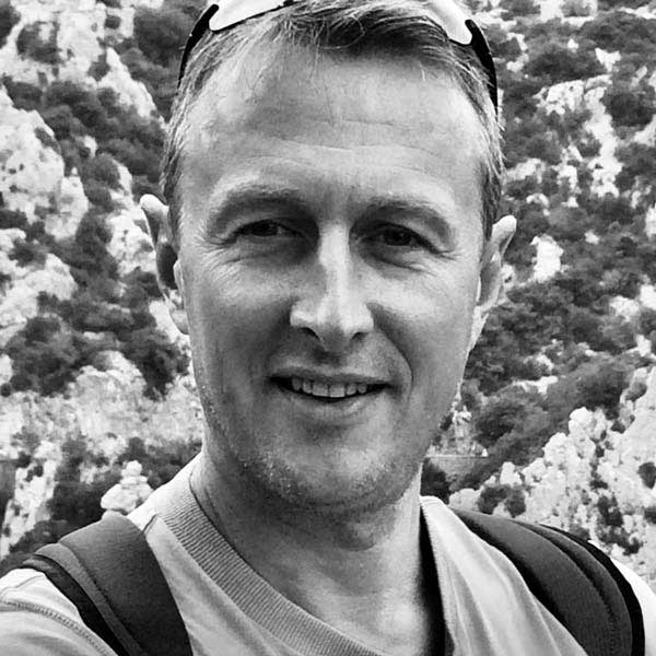 a man with a backpack smiles at the camera