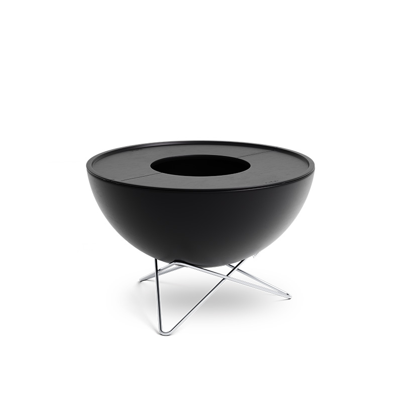 An inviting scene with a black bowl with a metal stand, highlighted by the presence of the 00263 Bowl 70 Plancha