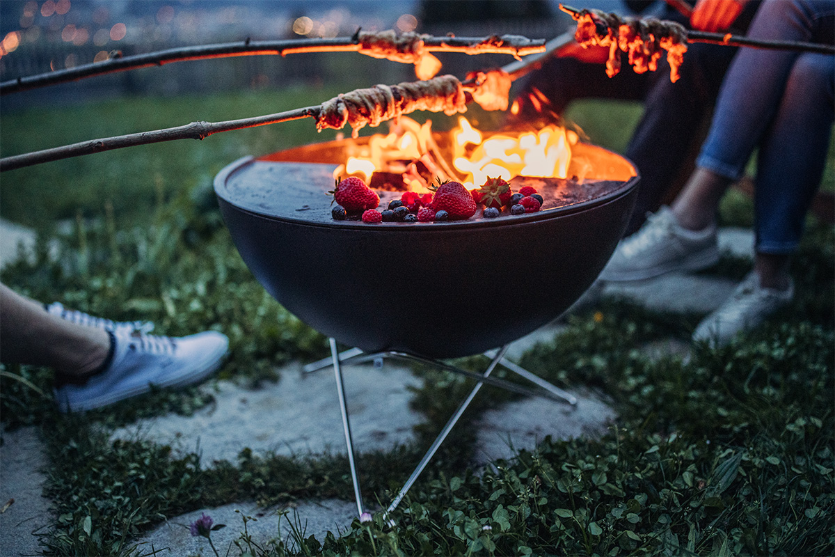 BOWL 57 Star stand A person is sitting on the grass, enriched by the presence of the 00343 Bowl 57 Star Stand, which merges design with utility.