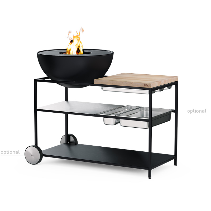 FIRE KITCHEN with BOWL 70 Plancha BBQ Set low A view of a black barbecue grill with a fire on top, with the FIRE KITCHEN with BOWL 70 Plancha BBQ Set incl. wheels.