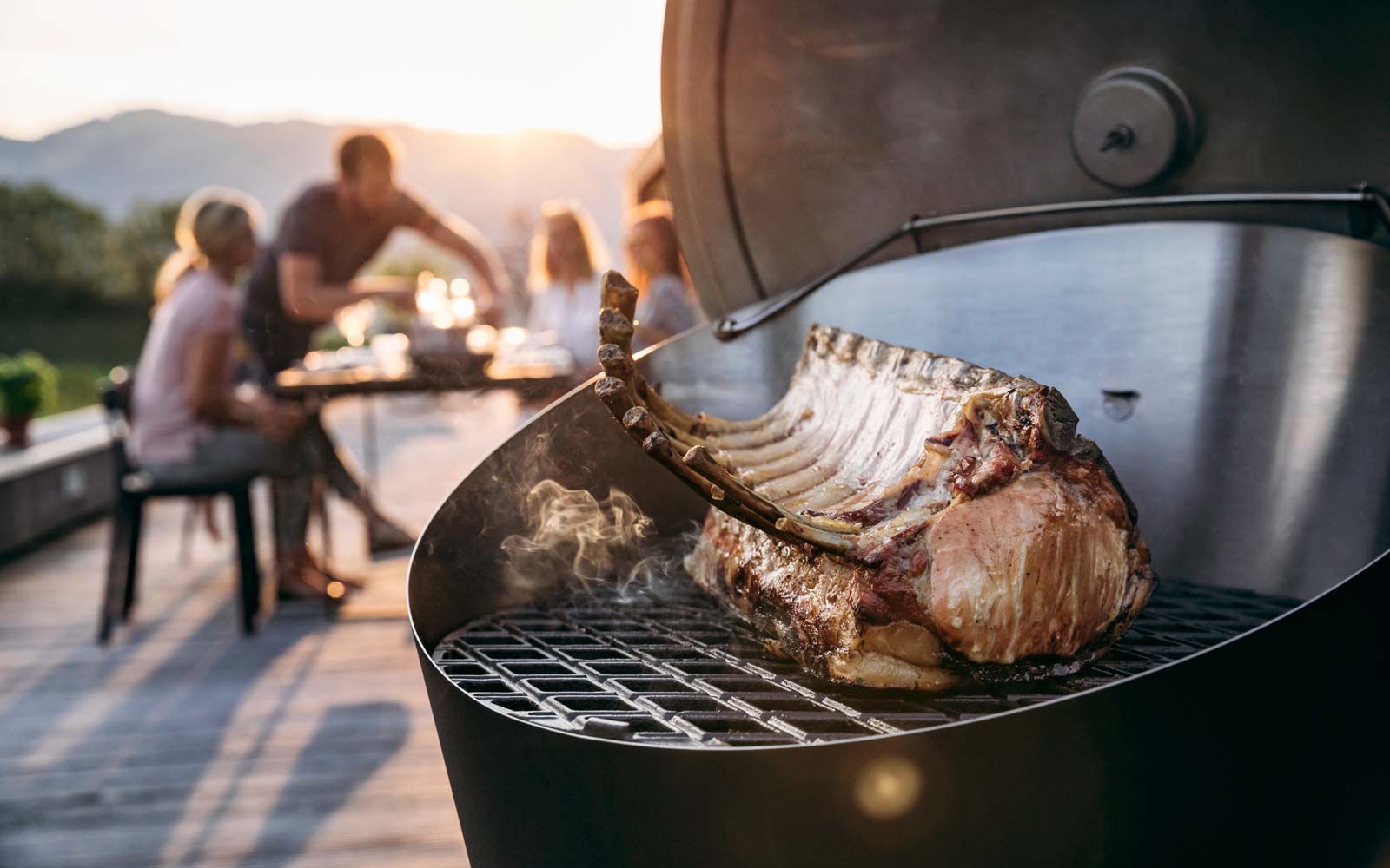 A person grilling a piece of meat on a grill, enriched by the presence of the 010301 CONE Cast Iron Grid, which merges design with utility.