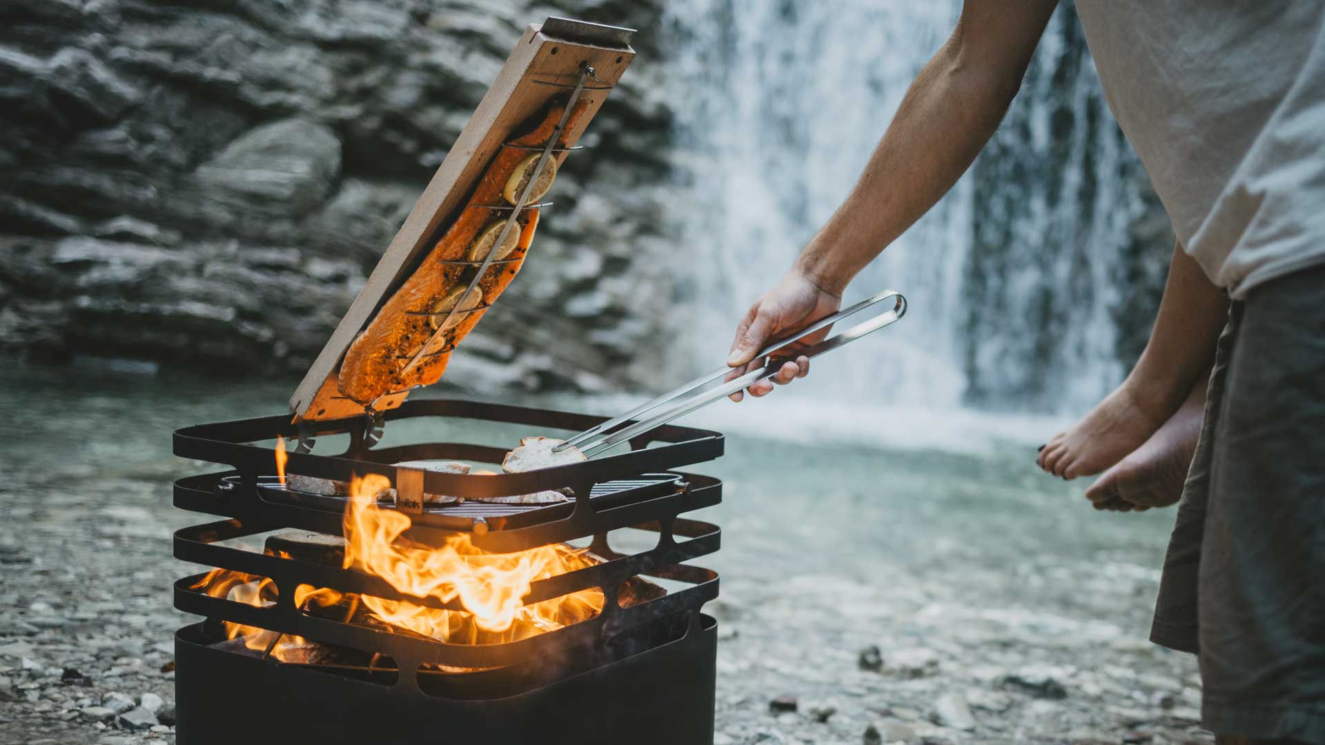 An inviting scene with a man is cooking food over a fire, highlighted by the presence of the Cube Ocean Set .