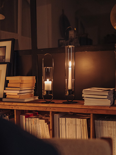 Scene showing a dark room in the evening, only lit by the light of the OVAL Candle Standing out for ist practical elegance