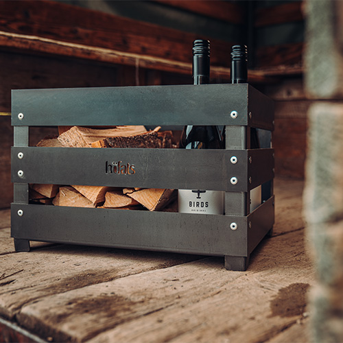 An image showing a wooden table, with the LOGO CRATE Fire basket.