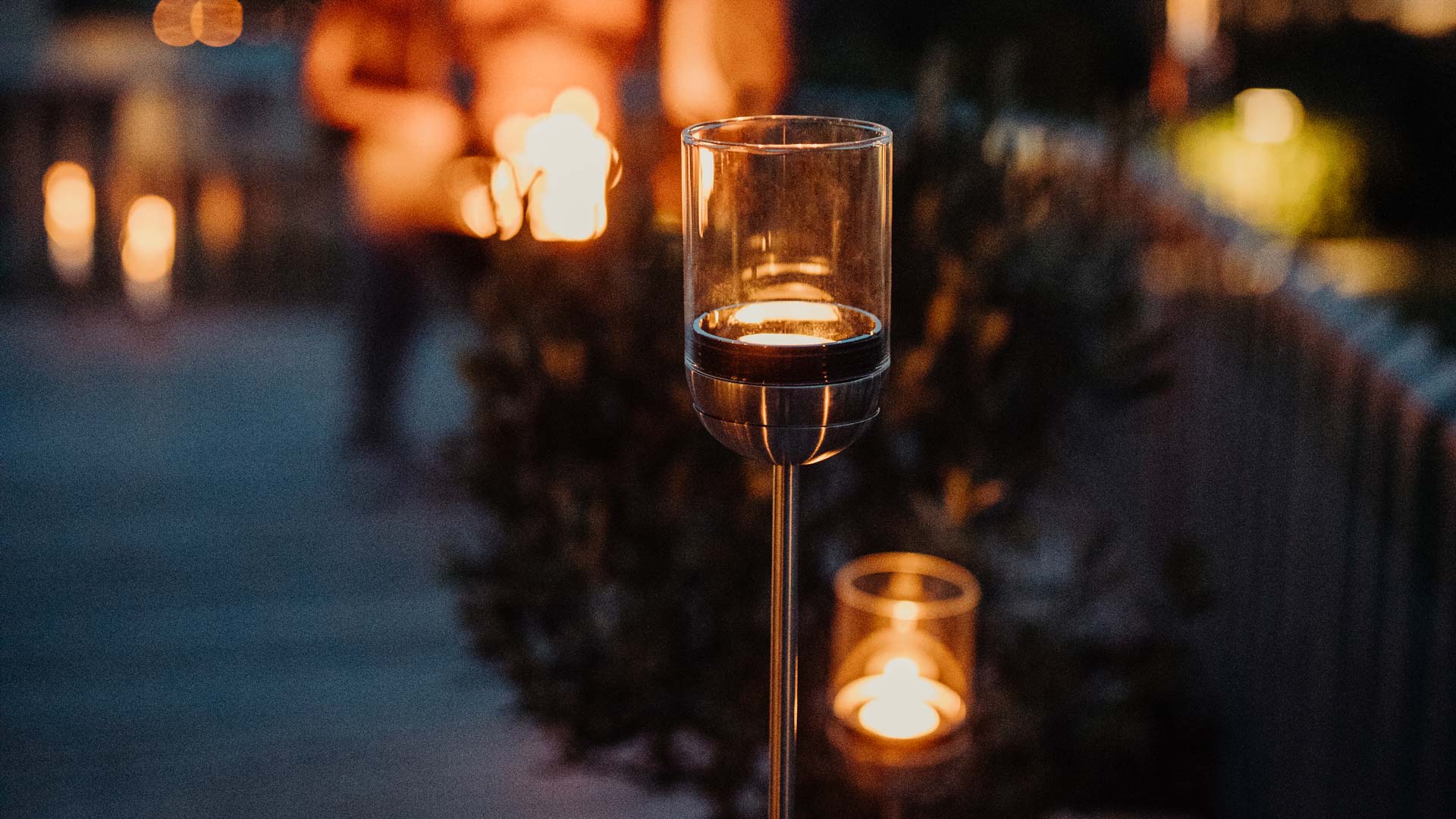 Illustrated is a candle lit up in the middle of a sidewalk, with the GRAVITY CANDLE Pole.