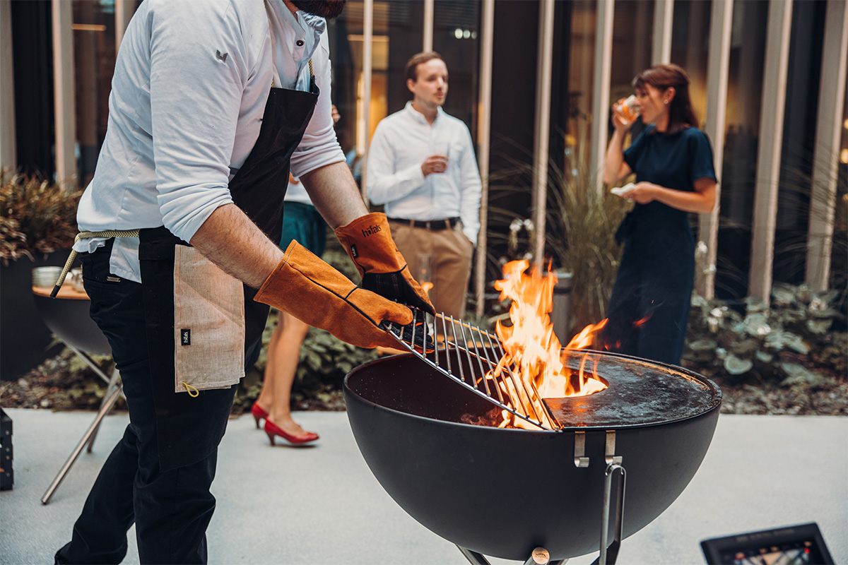 This image shows a man cooking on a grill, with the BOWL 70 Grid.