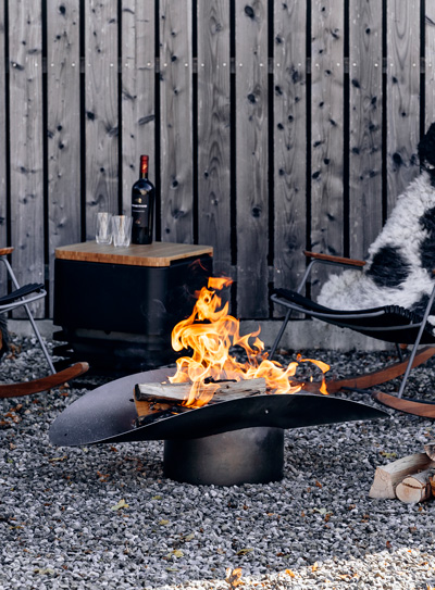 A chair next to a fire pit the 060101 ELLIPSE Fire Bowl complements the moment with its thoughtful design.