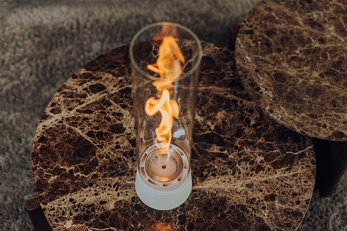 SPIN air 900 Tabletop Fireplace cream SPIN air 1200 creme steht auf einem braunen Marmortisch Vogelperspketive