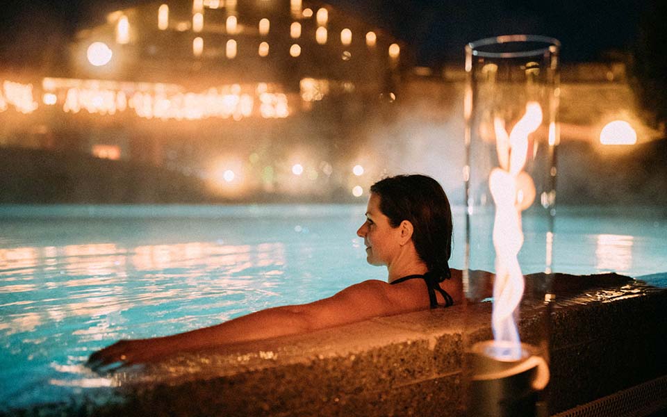 This image shows a woman in a hot tub at night, with the Atmospheric image Christmas for Console.