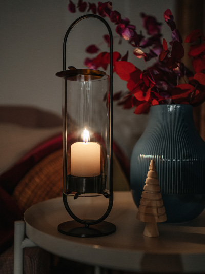 A depiction of a candle and a vase on a table, featuring the Oval Candle as a central and purposeful element.