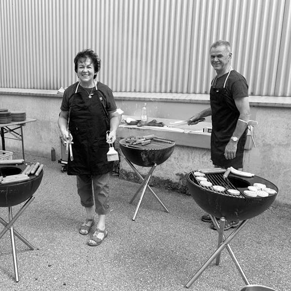 two women are cooking on a grill outside