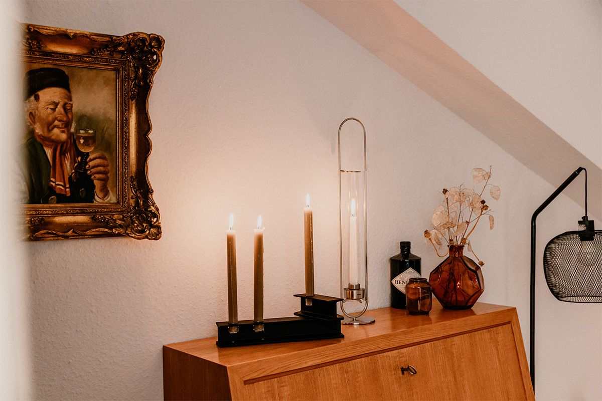 A picture of a man on a wall, enriched by the presence of the 00271 Oval Candle 55, which merges design with utility.