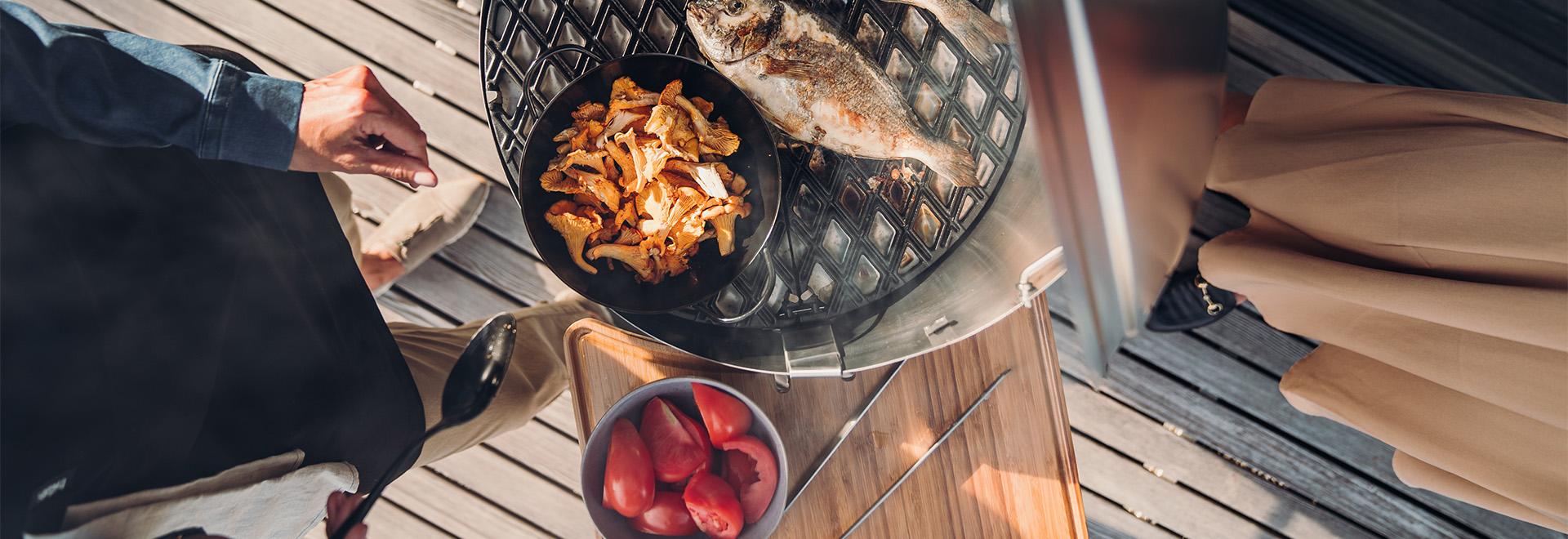 An image showing a man is cooking food on a grill, with the CONE.