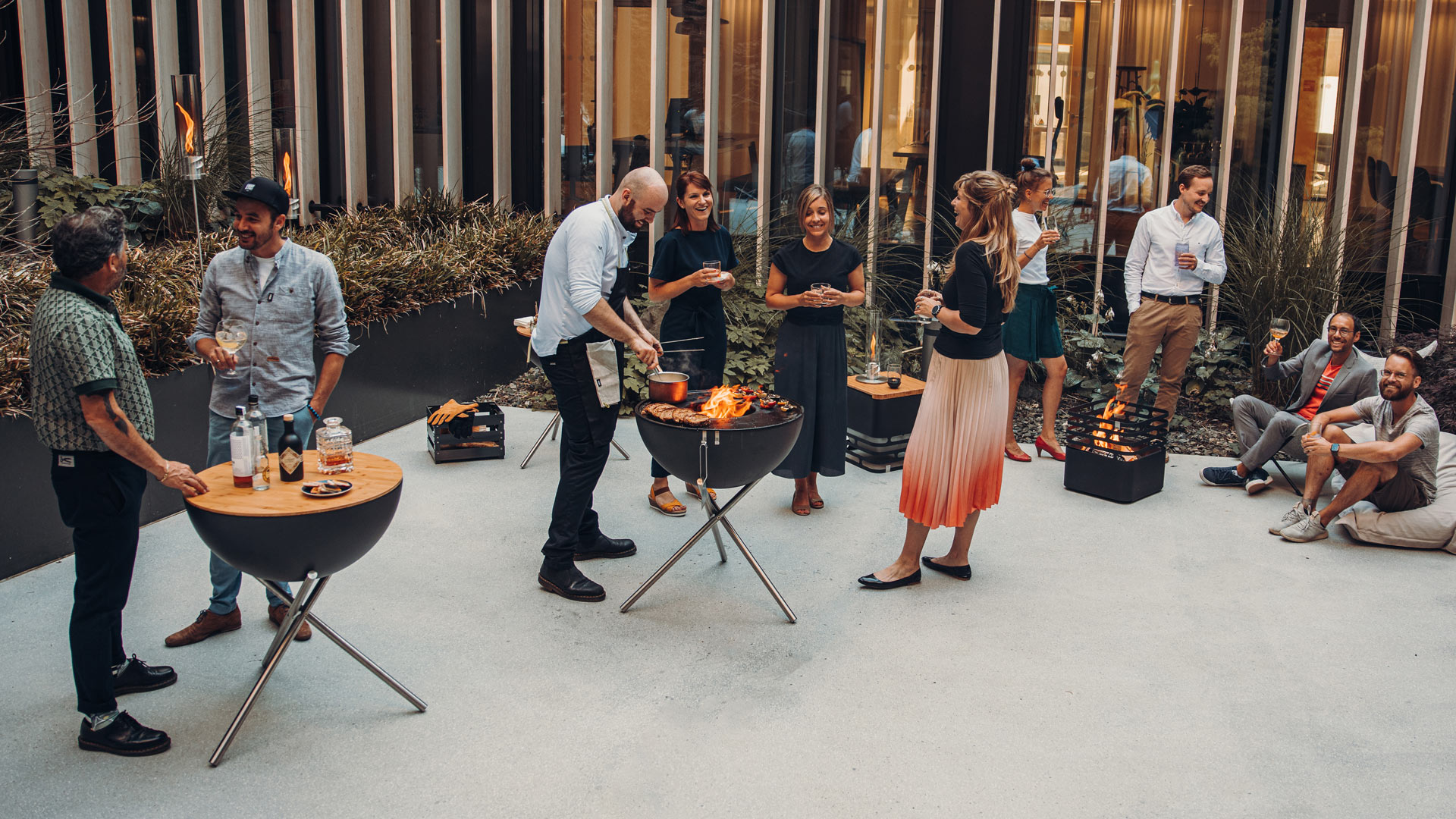 Experience a group of people standing around a table with the refined touch of the 00258 Bowl 70 with Tripod.
