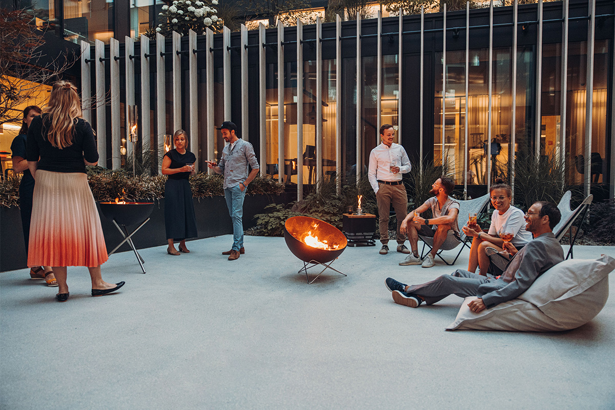 Bowl 70 star stand A group of people sitting on a patio, with the 00259 Bowl 70 Star Stand adding a functional and elegant touch to the scene.