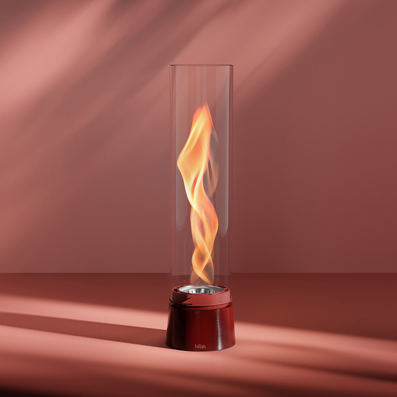 SPIN air 1200 Tabletop Fireplace enamel red A flame in a glass cylinder with a red base, with the 00814 Spin Air 1200 Tablefire Emaille red adding a functional and elegant touch to the scene.