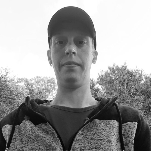 a man in a baseball cap and sweater.