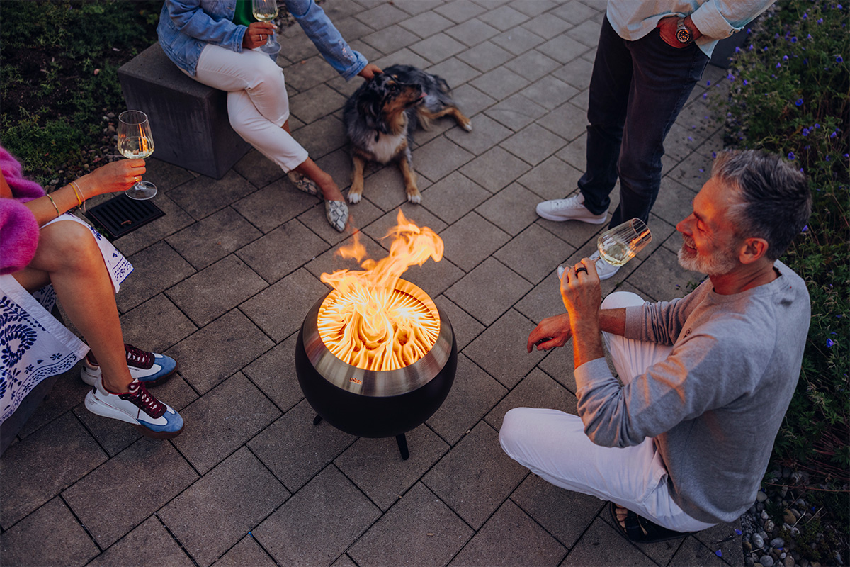 MOON Feuerkorb brennt und Menschen sitzen dabei um die MOON
