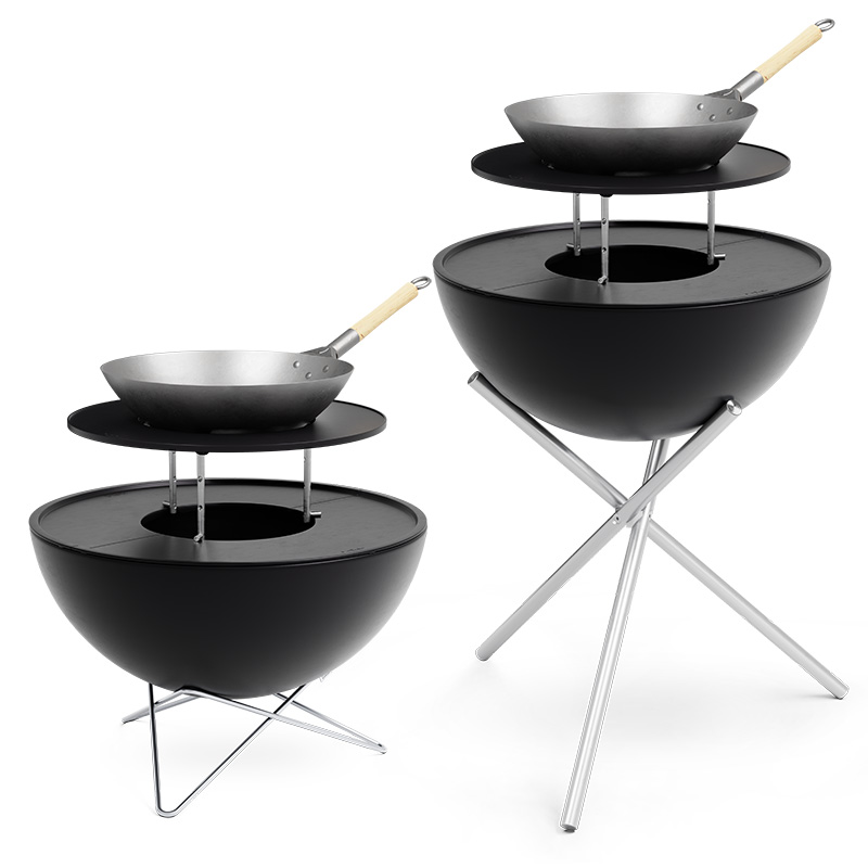 An image showing a black barbecue set with two pans and a spat, with the BOWL 70 Warming Ring.