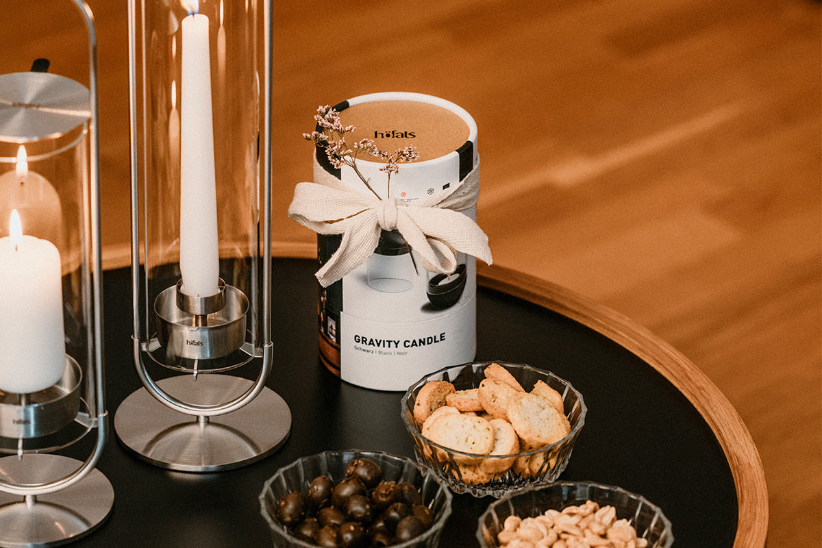 GRAVITY CANDLE Lantern black a table with a candle, a bowl of nuts, and a candle holder with the refined touch of the Gravity Candle