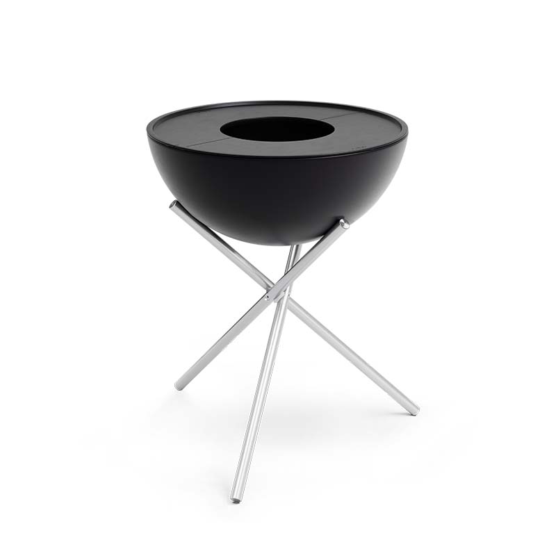 The black bowl is on a metal stand, with the 00256 Bowl 57 Plancha adding a functional and elegant touch to the scene.