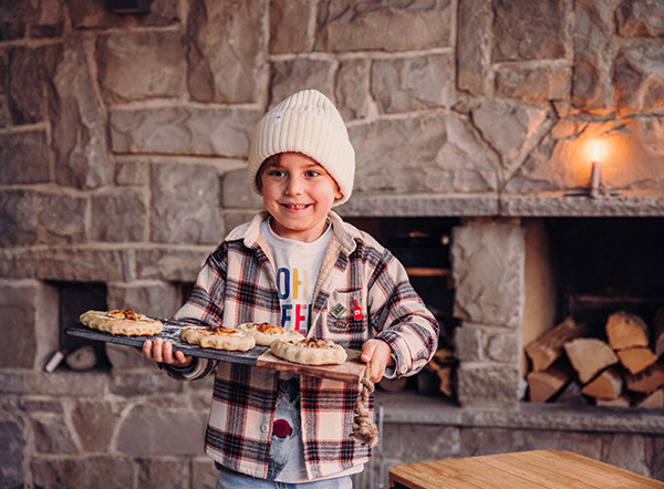 Mini pizza over the fire a boy holding a pizza.