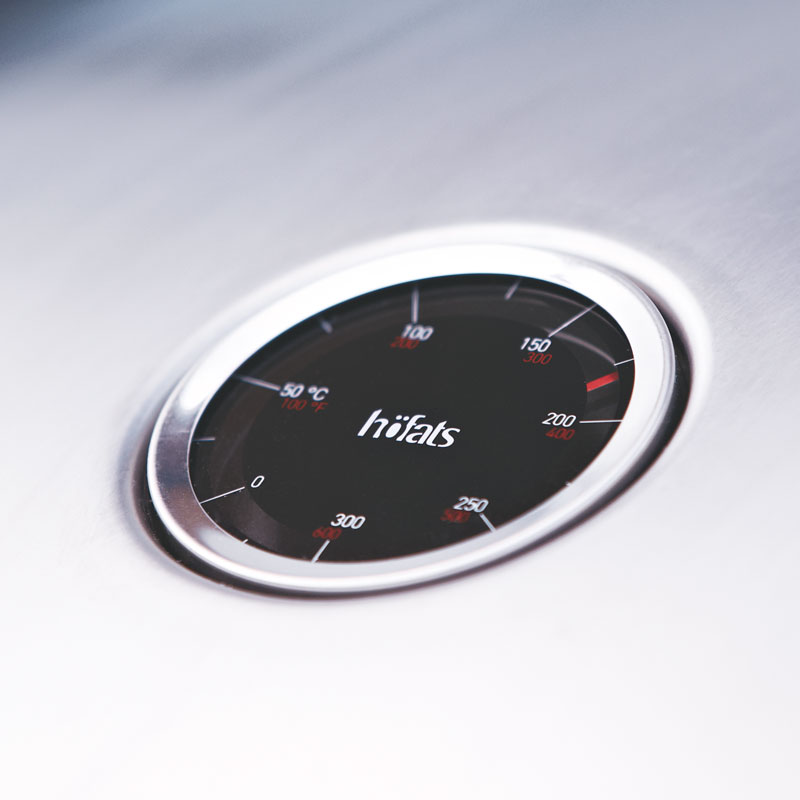 a close up of a clock-thermometer on a table