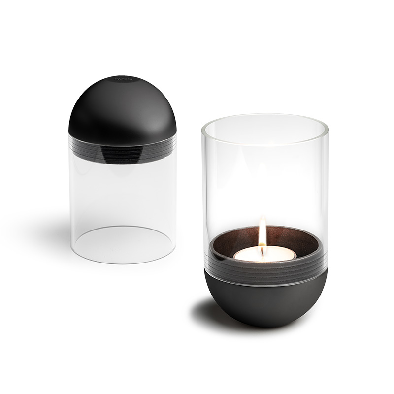 A view of a candle and a glass container, with the GRAVITY CANDLE Lantern black.