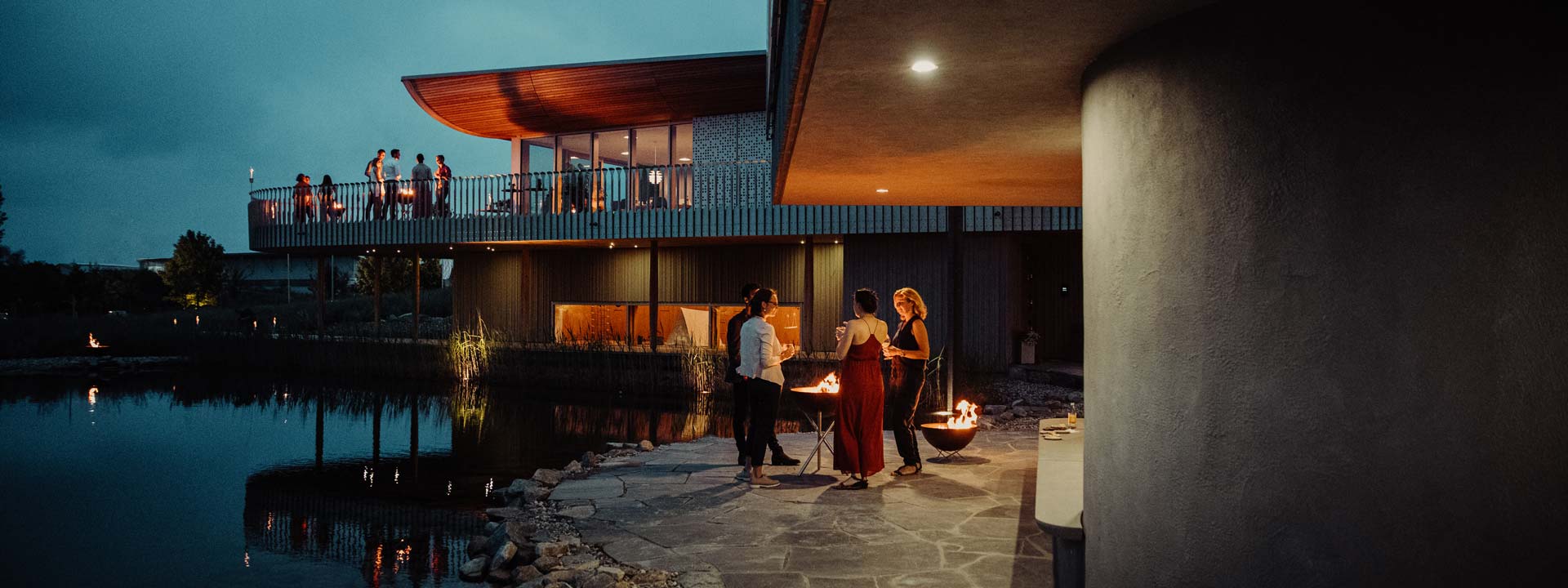A couple standing outside at night, enriched by the presence of the Bowl Firebowl, which merges design with utility.