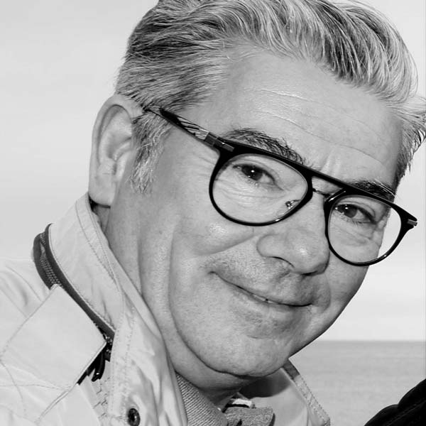 a man with glasses and a white shirt.