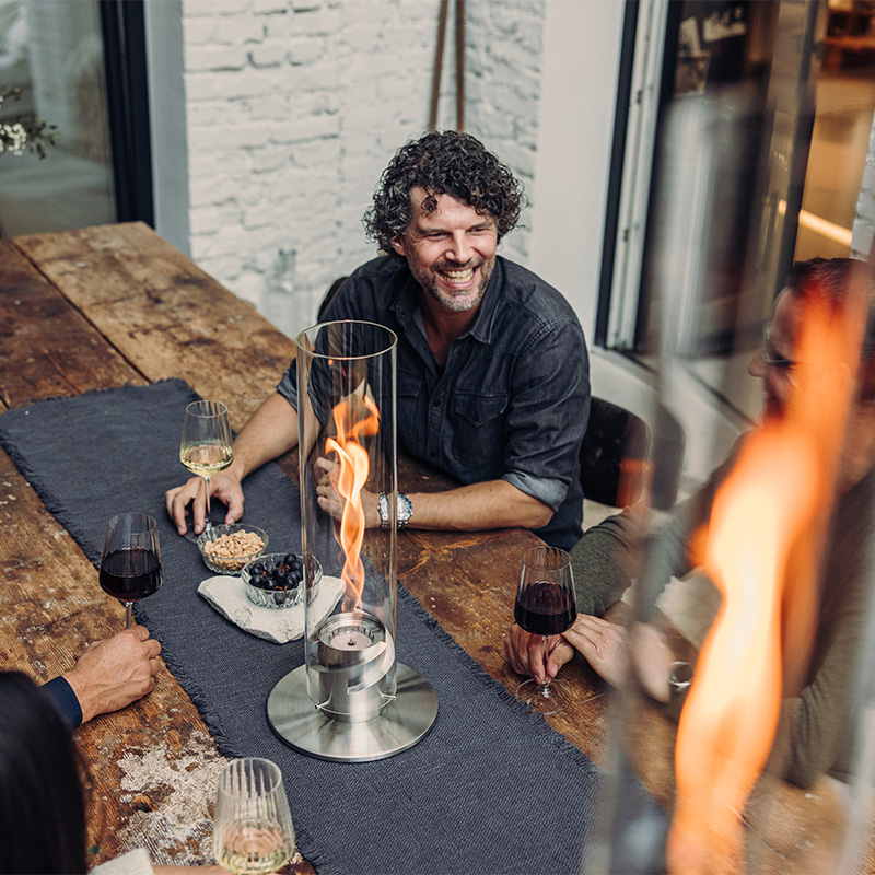 A group of people sitting around a table, with the Spin 900 and SPIN 1200 are adding a functional and elegant touch to the scene.