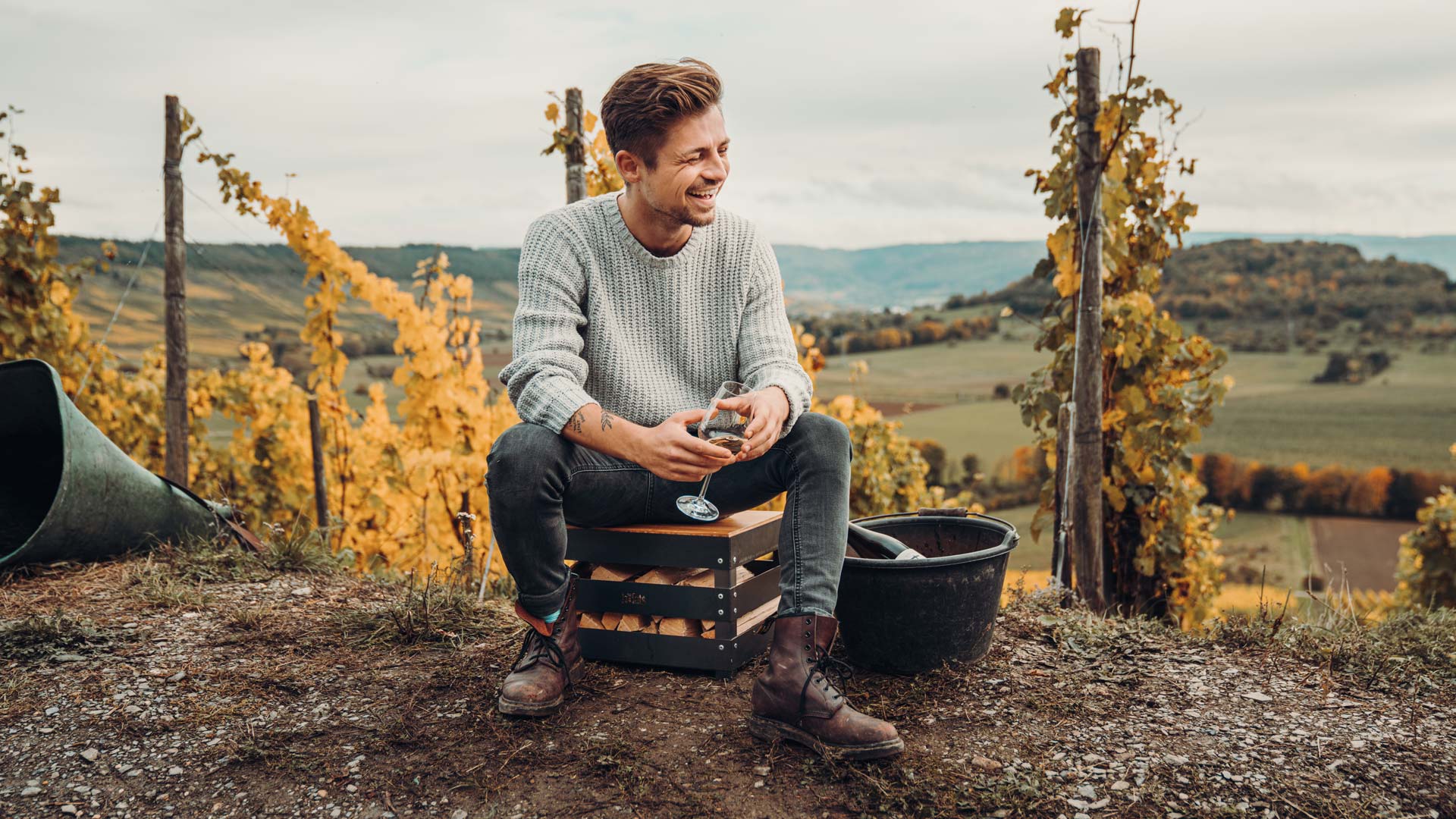 A man sitting on a hill with a bucket, with the Crate Board adding a functional and elegant touch to the scene.