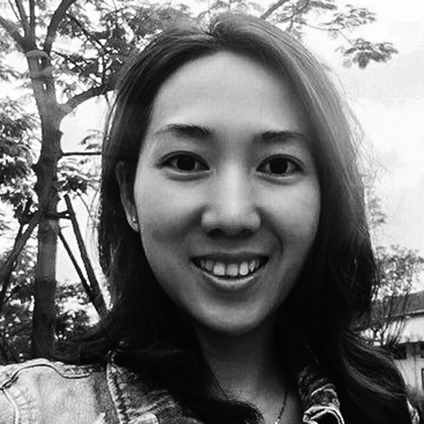 a woman standing in front of a tree.