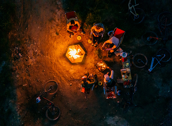 Fire etiquette a group of people sitting around a fire pit.
