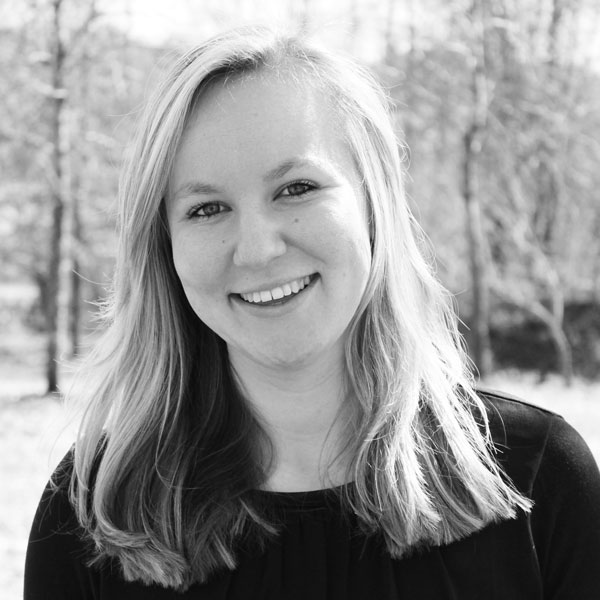 a woman in a black shirt smiles at the camera.