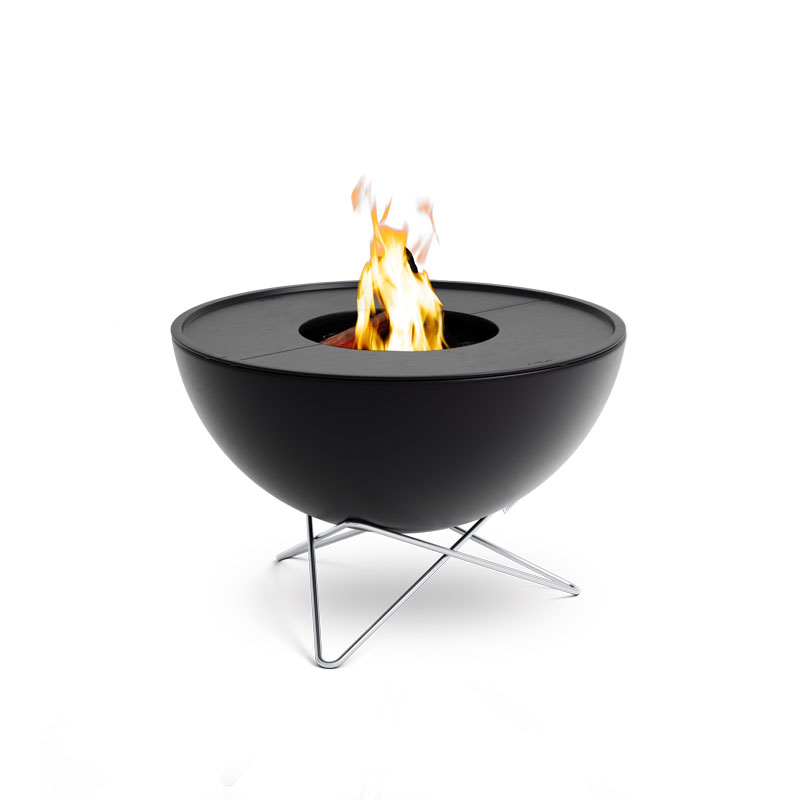 Depicted here is a black fire bowl with a flame on top, with the BOWL 70 Plancha BBQ Set low.