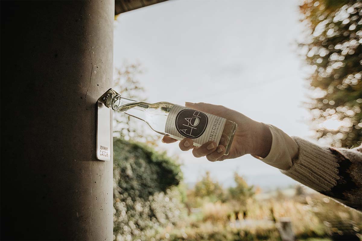 A person holding a bottle of water, with the Johnny Catch Magnet Bottleopener adding a functional and elegant touch to the scene.