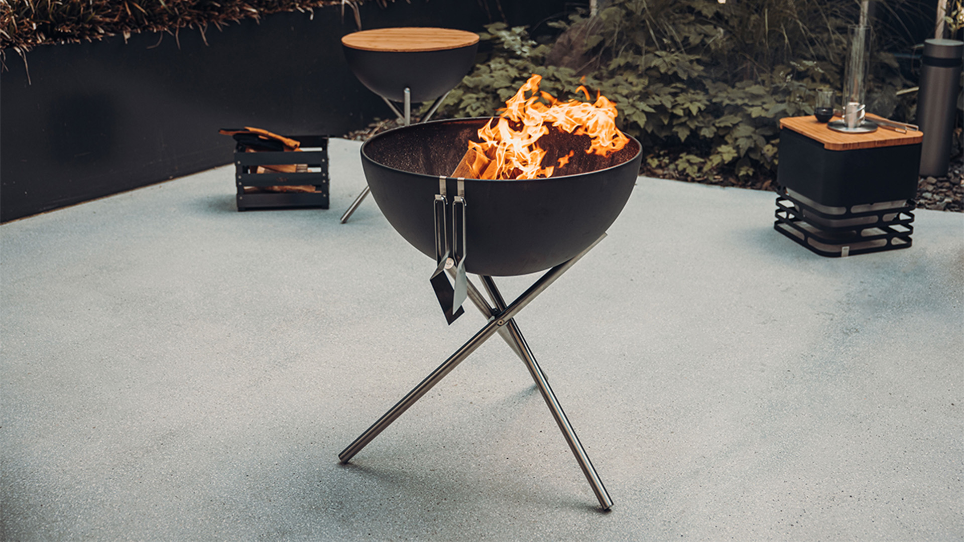 A view of a fire pit with a fire in it, with the BOWL 70 Tripod.
