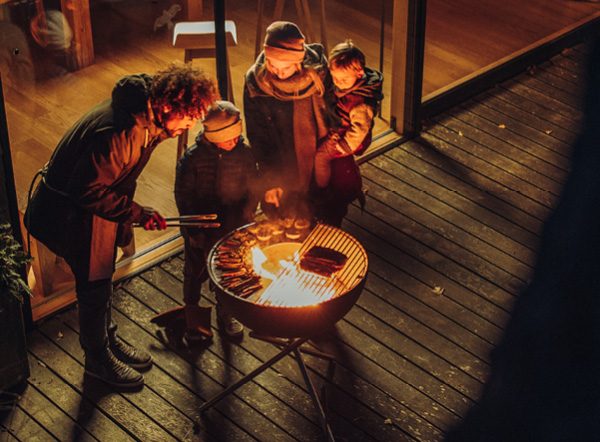 Bowl 70 with tripod is shown as three people are standing around a fire pit, creating a stylish and accessible visual.