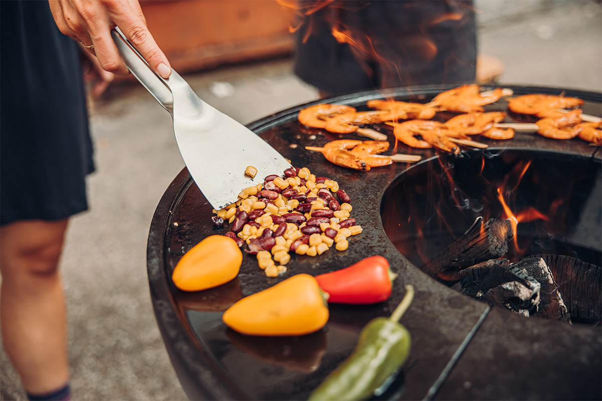 Depicted here is a person is cooking food on a grill, with the .