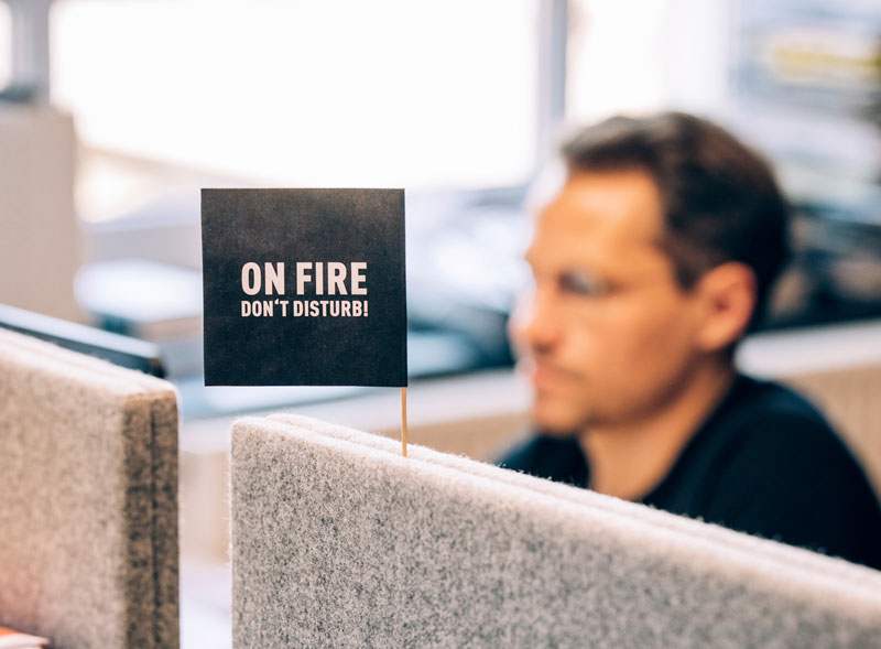 a man sitting at a desk with a sign on it.