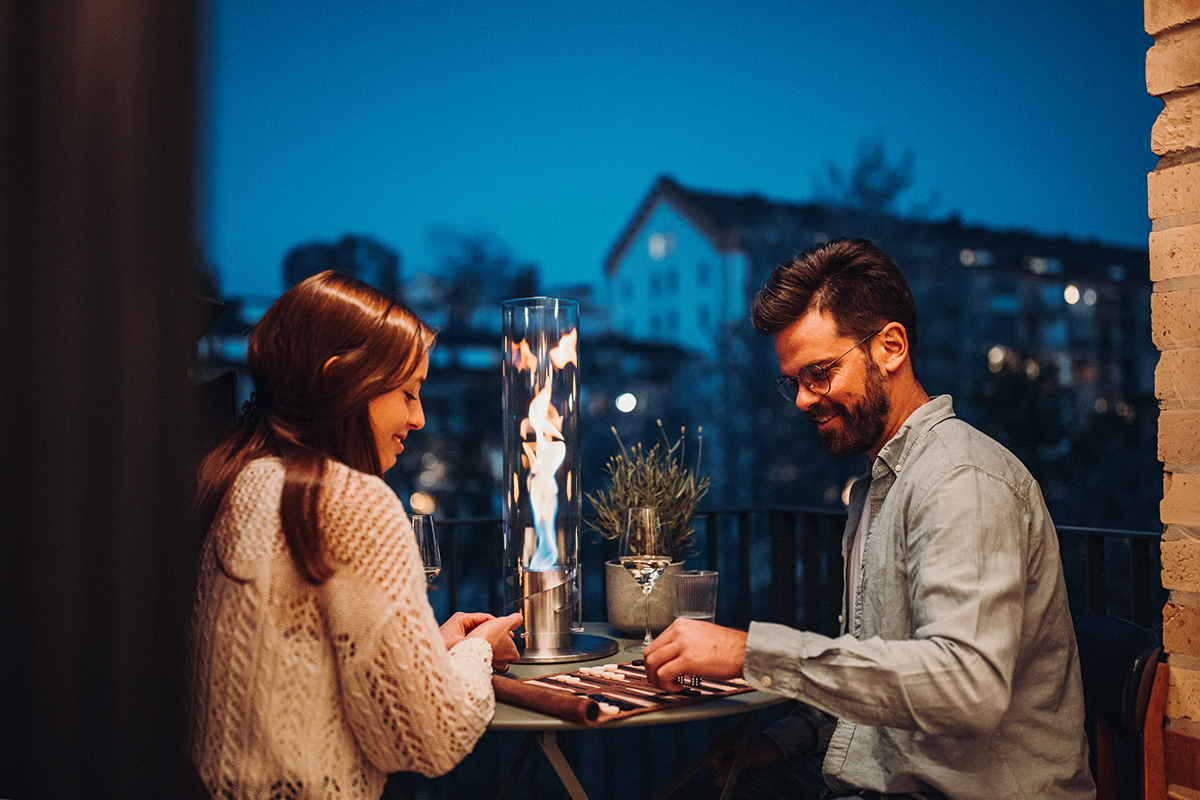SPIN 90 Tabletop Fireplace silver The Spin 90 Tablefire silver integrates seamlessly into the setting, where a man and woman sitting at a table with a candle.